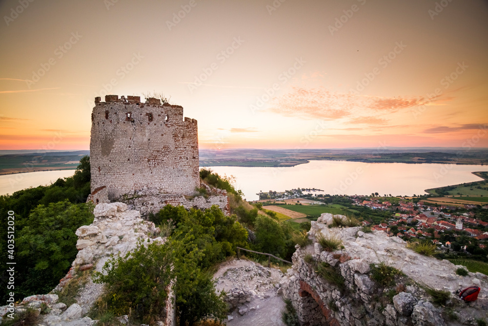 castle ruins and lake during sunrise