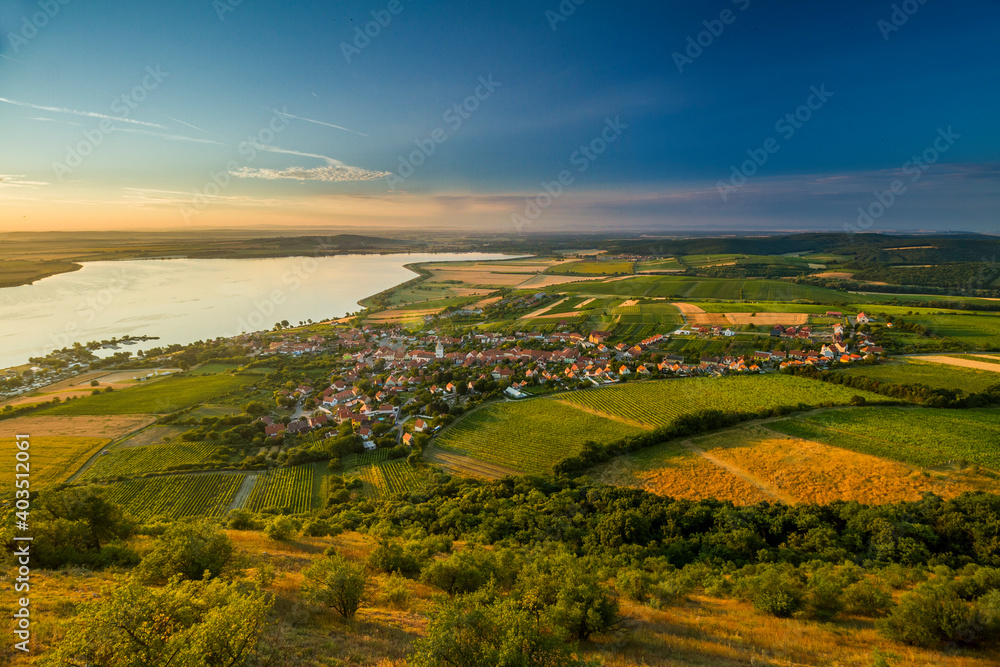 village in eastern europe during sunrise winery fields and lake