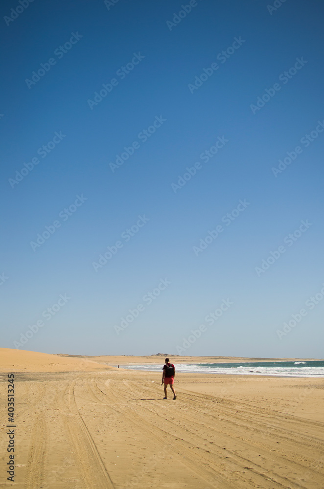 Hombre solo caminando en la playa 