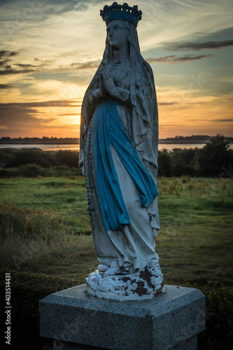 madonna statue in a sunset landscape photo