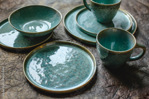 Handmade turquoise earthenware on a brown background.