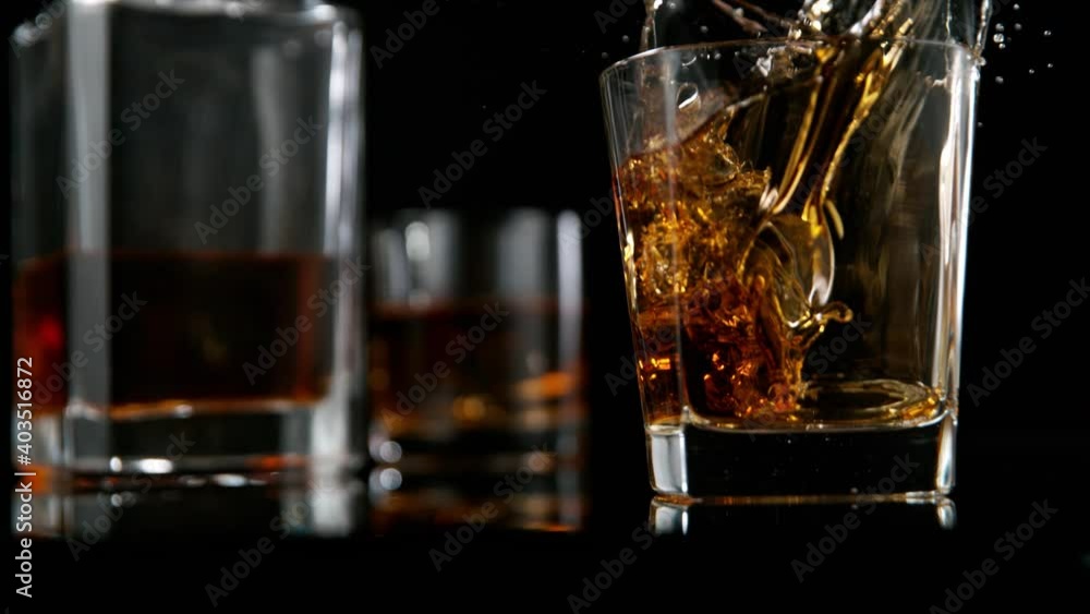 Camera Follows Ice Cube falling into Glass of Whisky in Super Slow Motion. Shot with High Speed Cinema Camera, 1000fps. Camera Follows Ice Cube falling into Glass of Whisky in Super Slow Motion. Shot with High Speed Cinema Camera, 1000fps.