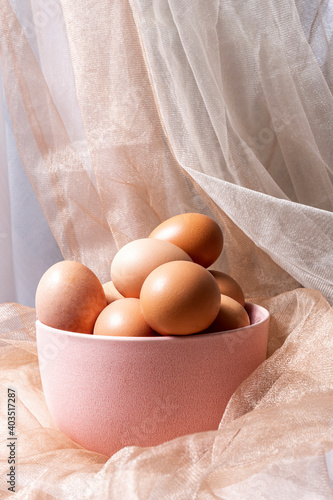 pink bowl with fresh eggs and tulle background