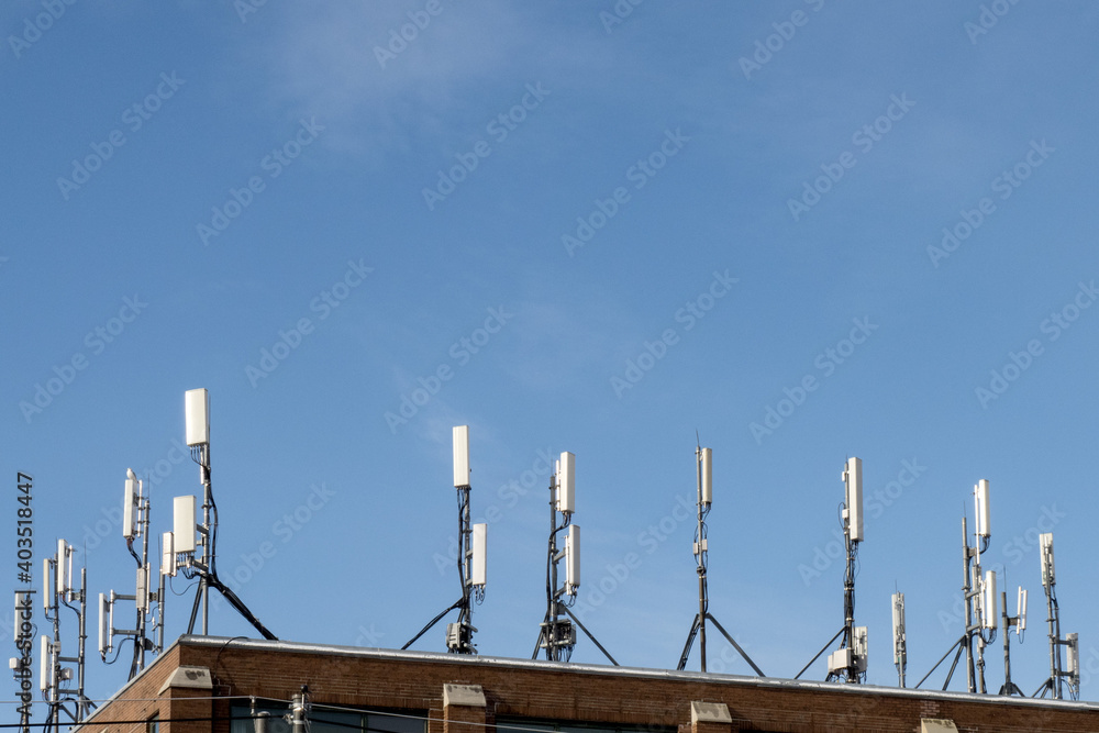 an array of cell phone antennae on a building in a city