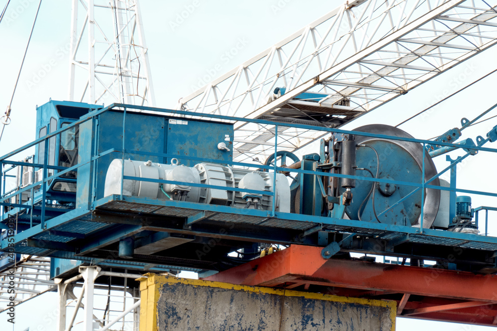 close up of the hoisting machinery and winch  of a construction tower crane on a building site