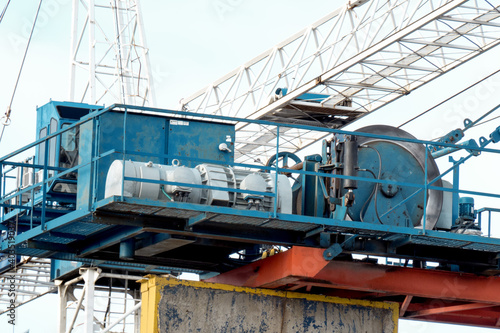 close up of the hoisting machinery and winch of a construction tower crane on a building site