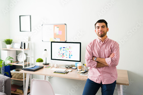 Happy latin man working at his home office desk