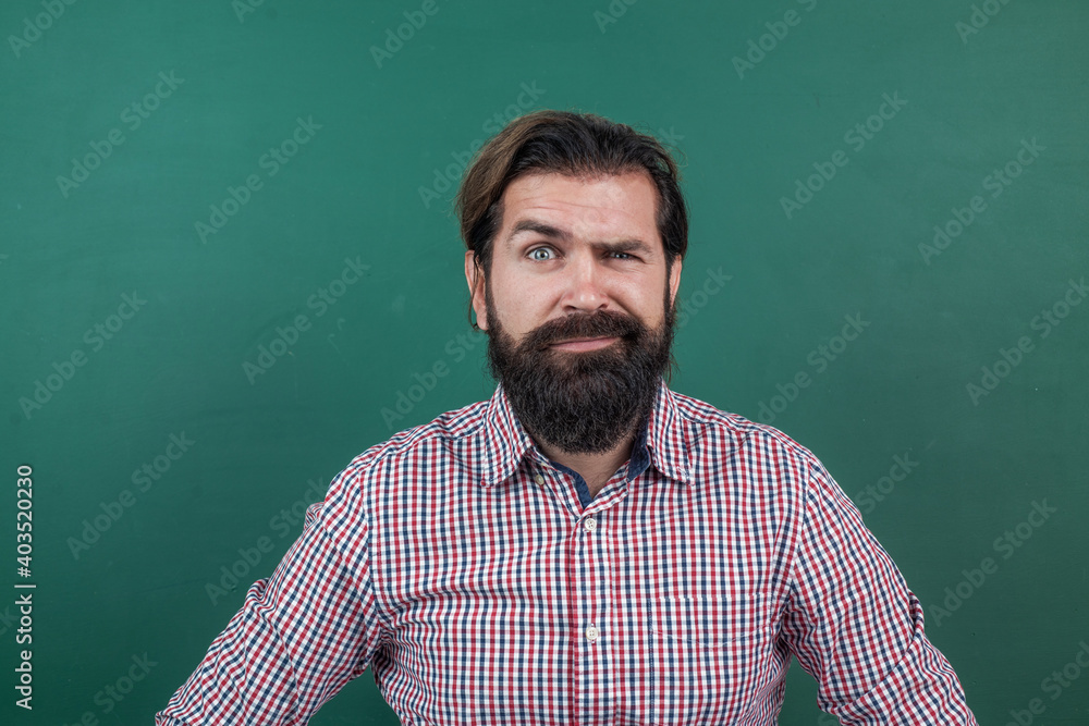 express human emotions. caucasian hipster with beard on green background. confused mature teacher on background of blackboard. brutal bearded man wear casual checkered shirt. he is so handsome express human emotions. caucasian hipster with beard on green background. confused mature teacher on background of blackboard. brutal bearded man wear casual checkered shirt. he is so handsome