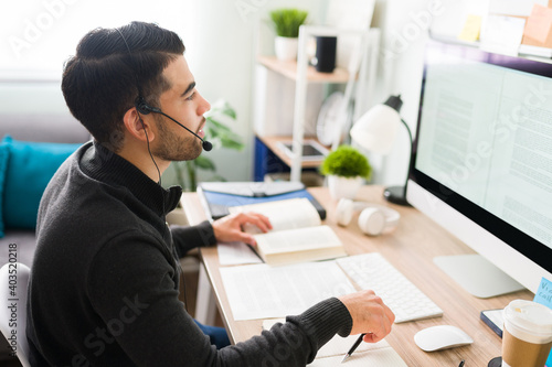 Photos Hispanic translator working at his home office desk