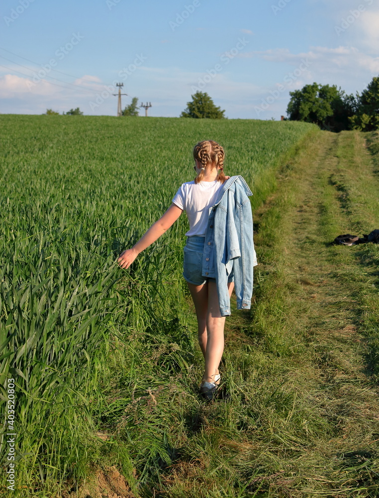 Blond young gril with braids  in field