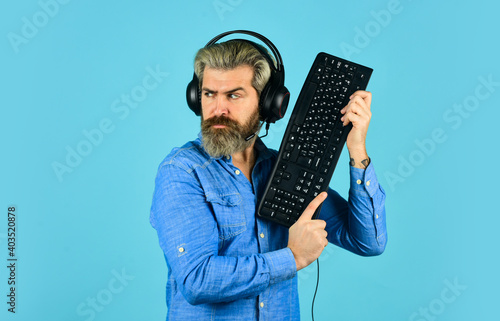 Online Cyber e-Sport Internet. gamer playing computer game. Digital Music Creation. bearded man headphones and keyboard. communication concept. support, call center and customer service help desk photo