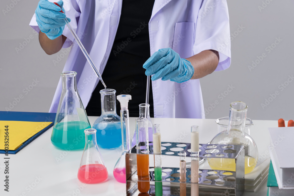 Cheerful chemist woman in lap, or graduate student in lab coat ane protetive wear work,check and test chemistry. Cheerful chemist woman in lap, or graduate student in lab coat ane protetive wear work,check and test chemistry.