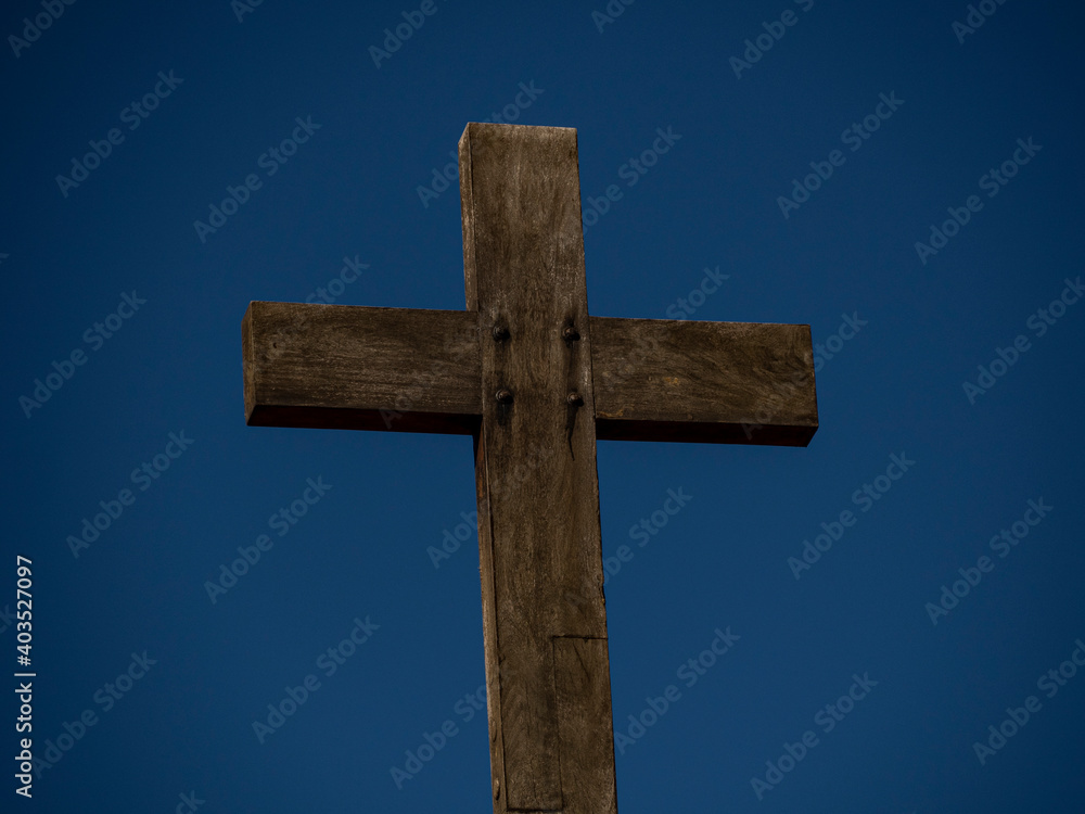 Cruz de madera con el cielo azul al fondo.