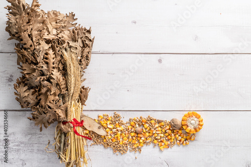 Fotografie Top view on oak branches with wheat and corn seed and nuts on wooden table with