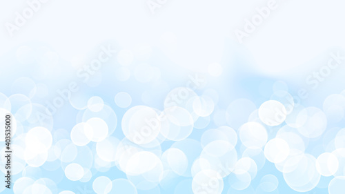 白色の玉ぼけと薄い水色の爽やかで明るい抽象的な背景イメージ素材