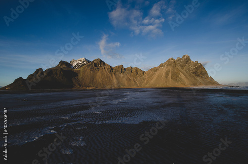 Jagged Vestrahorn Mountain in Iceland during winter with clear sky. With iced over beach.