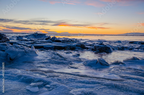 Sunset over the ocean and cracked ice field, on a winter day in Iceland.
