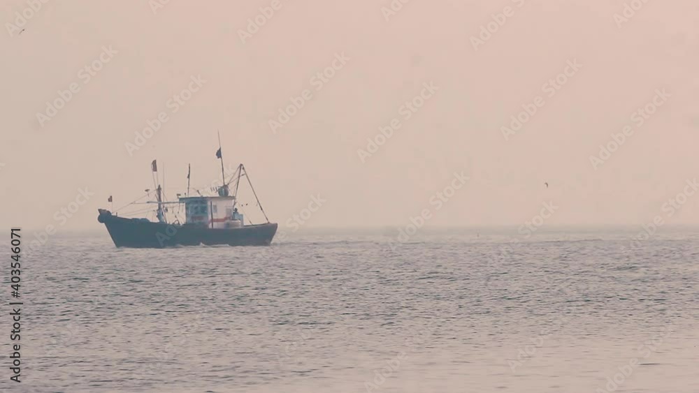 A Small fisherman boat sailing in middle of the ocean during sunset with small calm waves and returning home in foggy weather video background in mov in full HD A Small fisherman boat sailing in middle of the ocean during sunset with small calm waves and returning home in foggy weather video background in mov in full HD