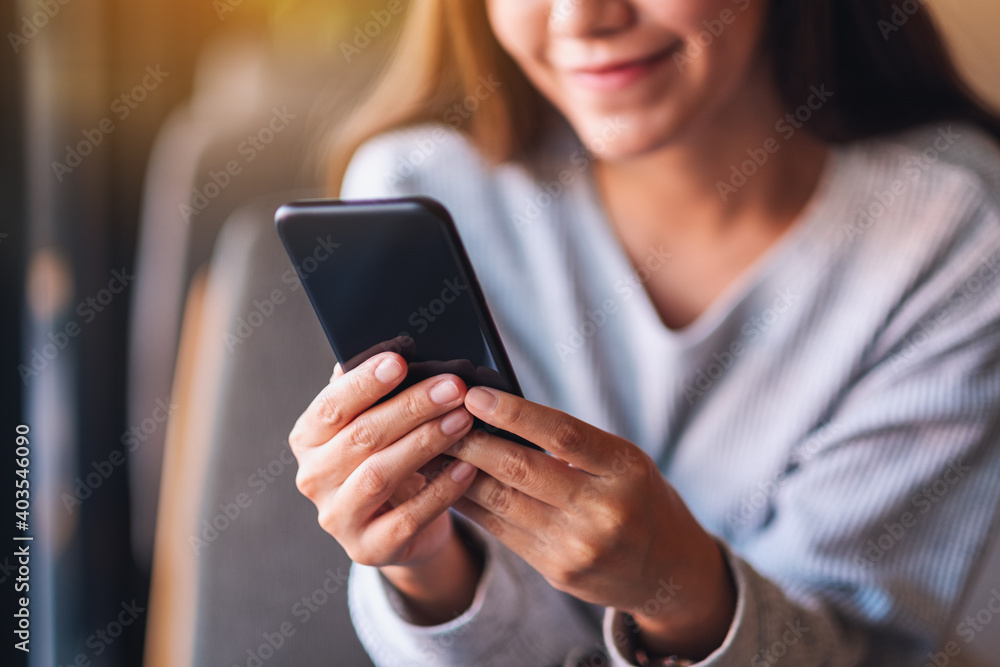 Closeup image of a beautiful young asian woman holding and using mobile phone Closeup image of a beautiful young asian woman holding and using mobile phone