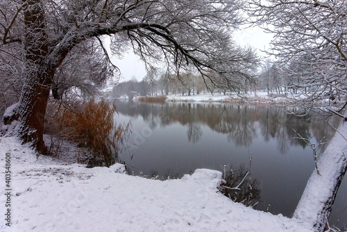 Snowy winter landscape with tranquil river or lake