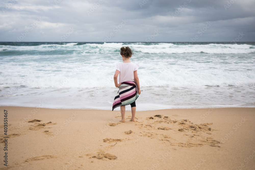 Young child from behind at the beach Young child from behind at the beach