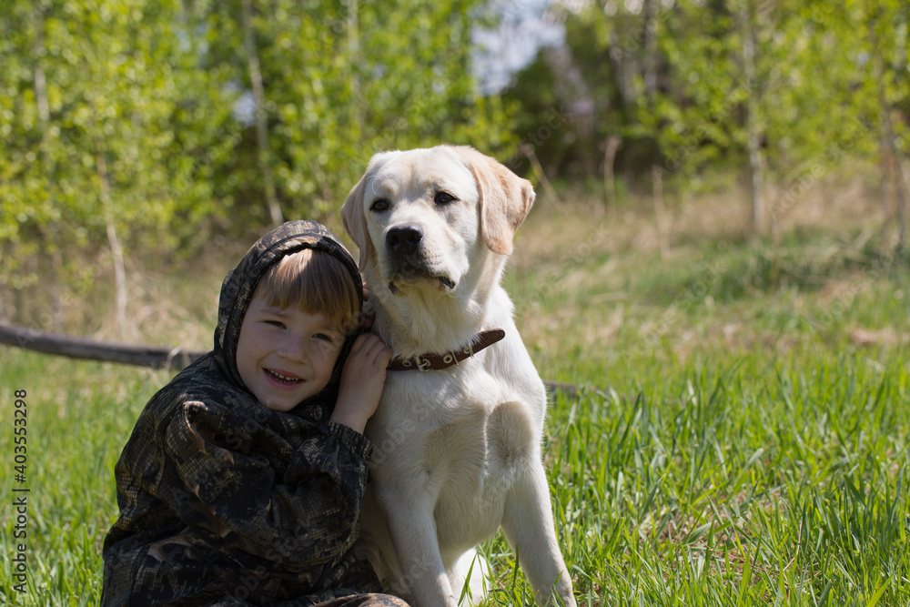boy hugs large dog. trust and love of man for animals. Labrador is child's friend and guard.