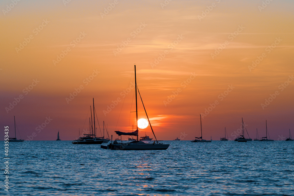 Sailing boats at Vesteys beach at sunset in Darwin, Australia.