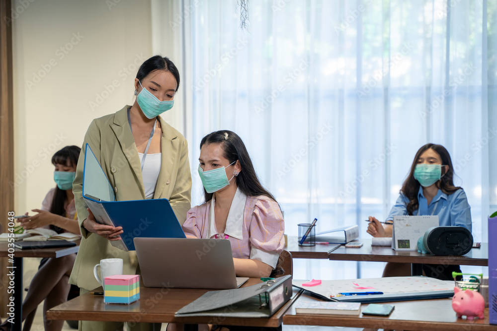 Asian business people wear protective face mask due covid working in office with new normal lifestyle.
