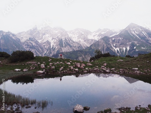 Panoramic view of hiker at Guggersee alpine mountain lake reflection in Allgaeu alps near Oberstdorf Bavaria Germany photo