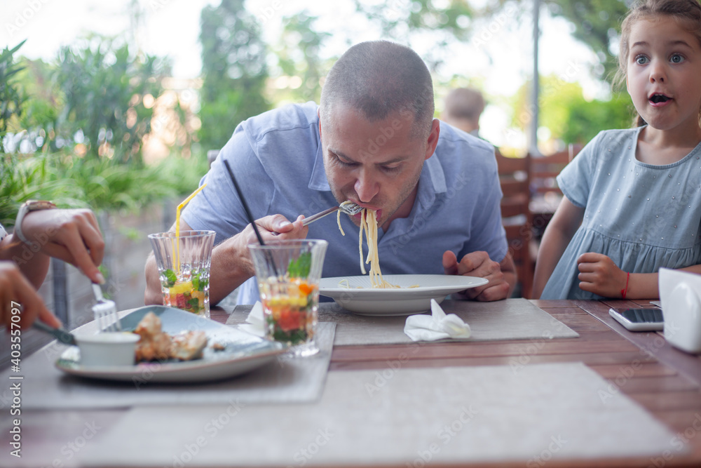 Happy family, mother father and kid eating pasta in cafe Happy family, mother father and kid eating pasta in cafe