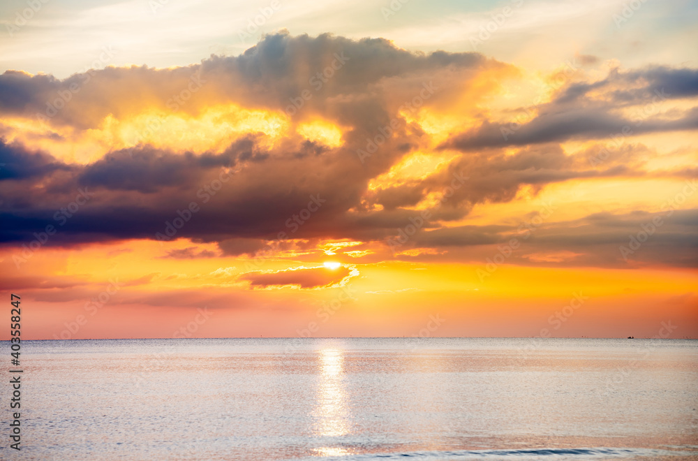 Fototapeta premium The sky and the sea with the orange sun in the evening. The sun is going to set. Orange sky background.