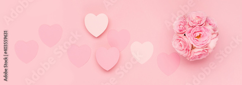 Flowers roses and pink paper hearts on pink background. Valentines day concept. Flat lay, top view, copy space.