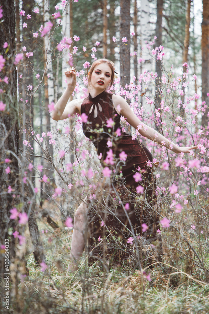 Japanese-style girl in a flowering forest among pink flowers in spring Japanese-style girl in a flowering forest among pink flowers in spring