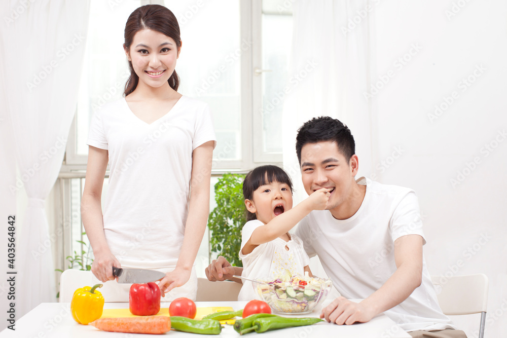 A happy family of three preparing a salad A happy family of three preparing a salad