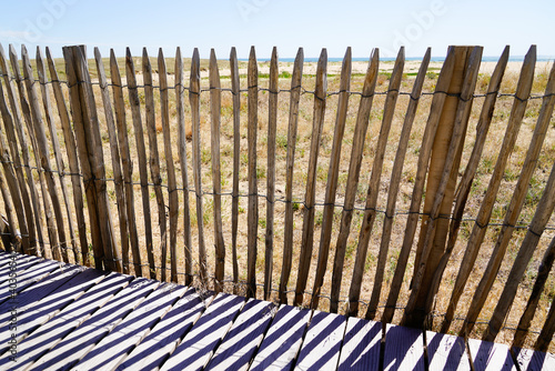 wooden protective barrier of the dune leading to the beach sea access walkway on atlantic ocean horizon in Jard sur Mer in france