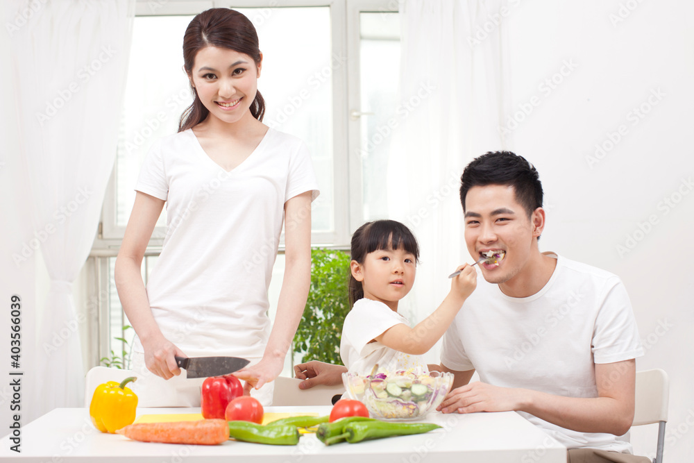 A happy family of three preparing a salad A happy family of three preparing a salad