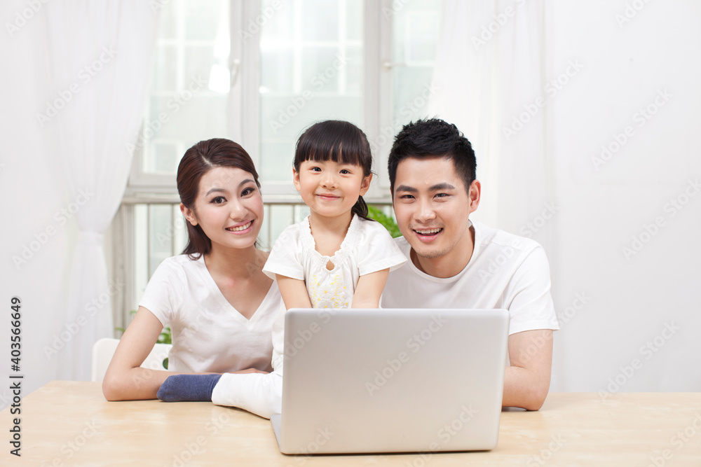Little girl using laptop with her parents Little girl using laptop with her parents