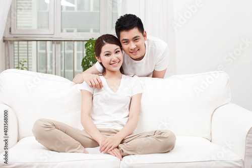 A happy young couple sitting in couch