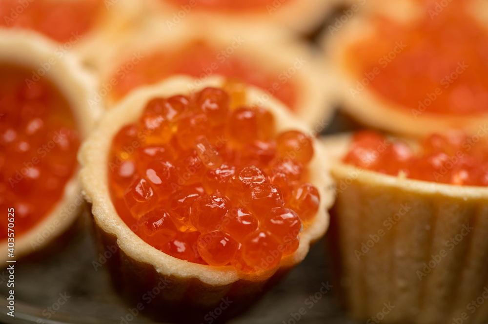 Tartlets with salmon caviar on a platter. Close-up, selective focus. Tartlets with salmon caviar on a platter. Close-up, selective focus.