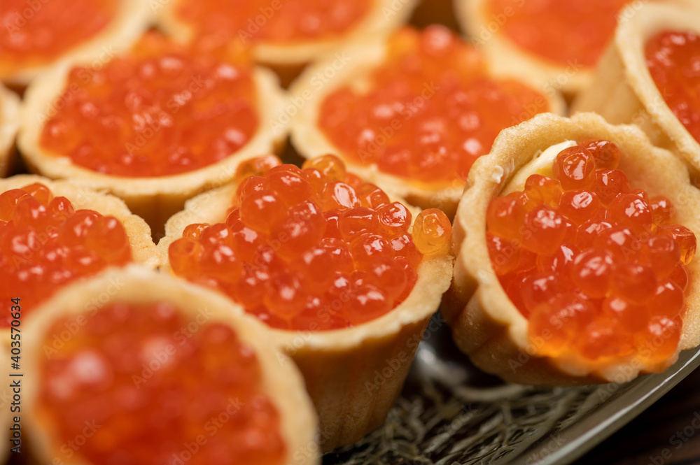 Tartlets with salmon caviar on a platter. Close-up, selective focus.