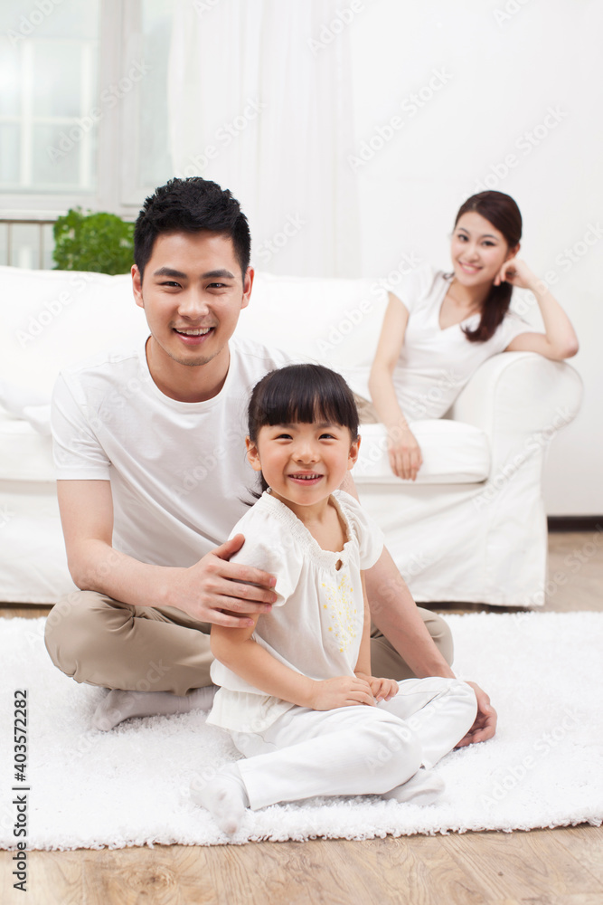 A happy family of three sitting in couch A happy family of three sitting in couch