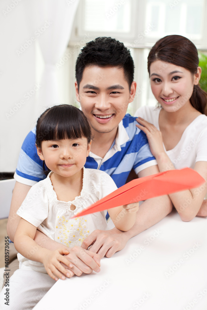 A family of three palying paper airplane A family of three palying paper airplane