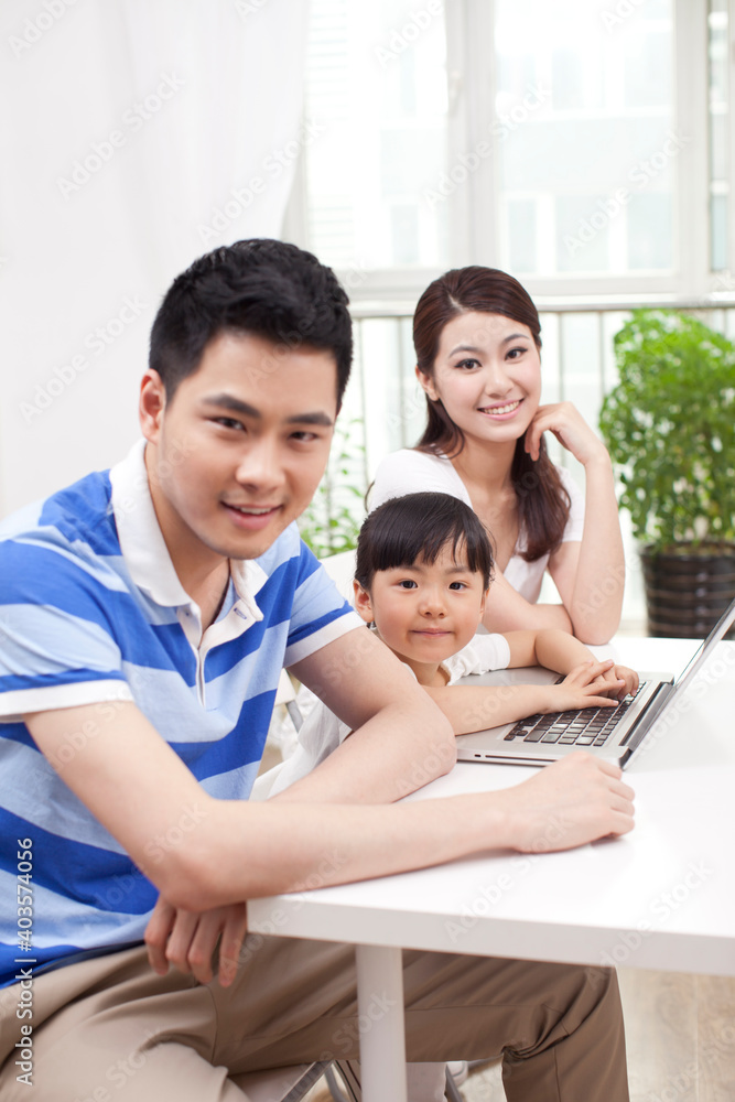 A happy family of three using laptop A happy family of three using laptop