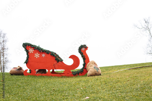 Fototapeta Naklejka Na Ścianę i Meble -  Big red sledge stands on a lawn