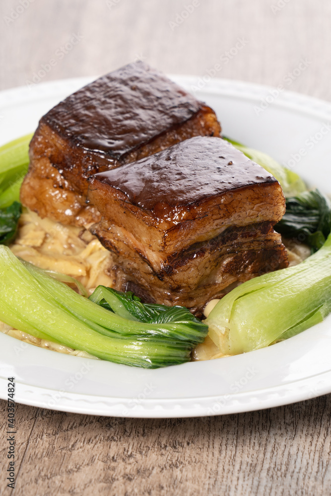 Dong Po Pork meat in a white plate with vegetable on wooden background. Dong Po Pork meat in a white plate with vegetable on wooden background.