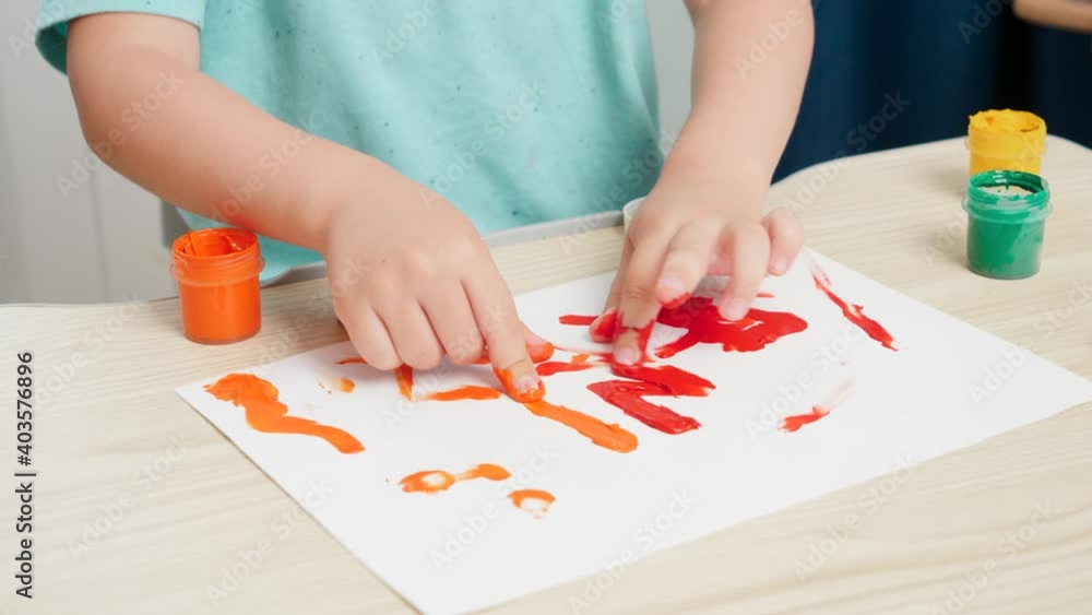 Closeup of little boy painting with colorful gouache paint on white paper. Concept of child education,, creativity development and art. Closeup of little boy painting with colorful gouache paint on white paper. Concept of child education,, creativity development and art.