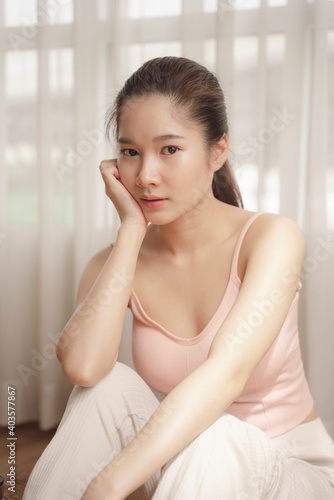 Portrait of young asian beauty woman in pink shirt in white room.