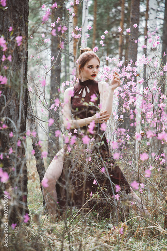 Japanese-style girl in a flowering forest among pink flowers in spring