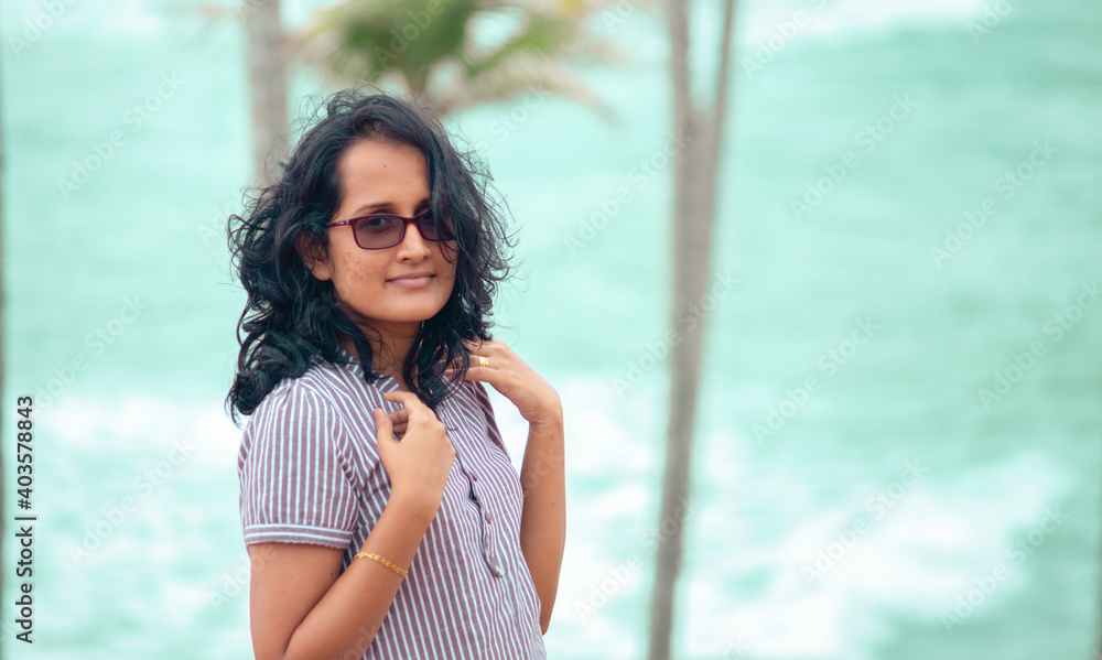 Beautiful innocent girl with spectacles posing for portraiture in the beach, South Asian model photoshoot.