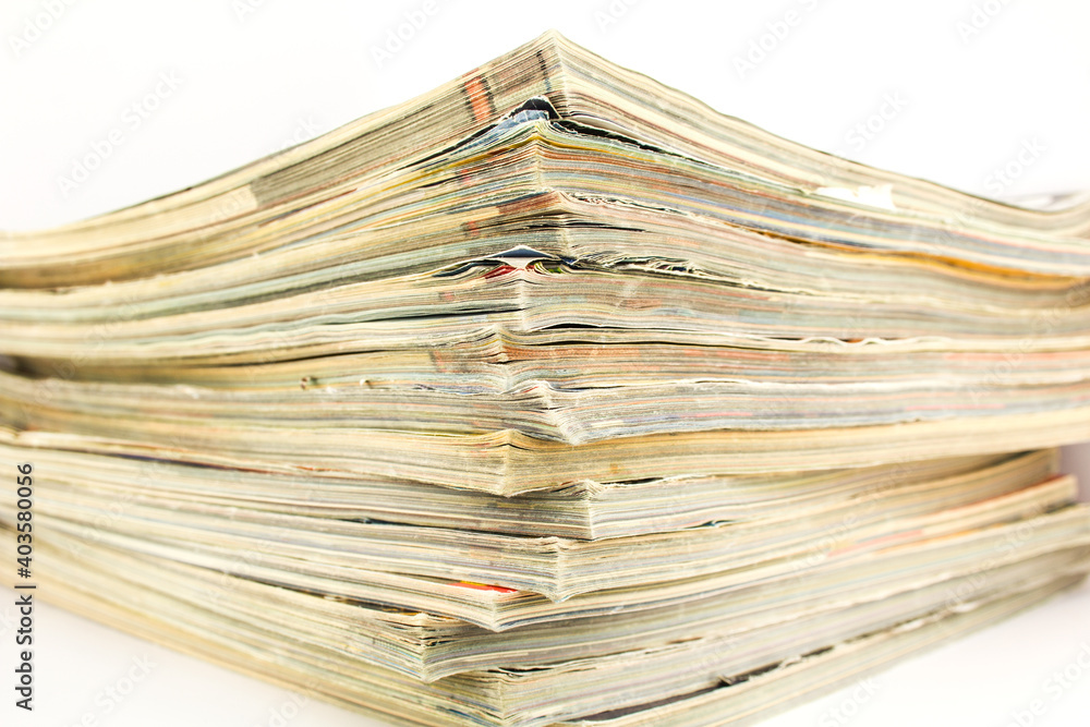 A stack of old shabby magazines on white background. A stack of old shabby magazines on white background.